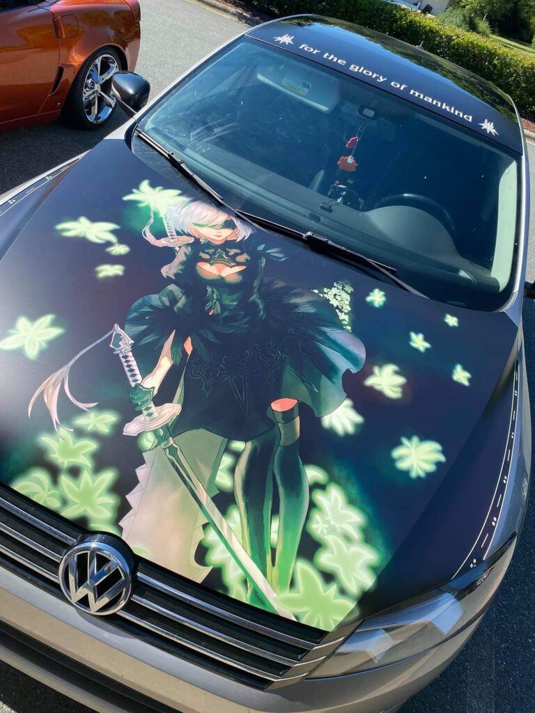 Itasha wrapped car that showcases 2B from Nier Automata prominently on the hood.